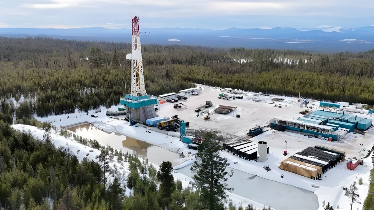 Geothermal well site with rigs and equipment in snowy Oregon landscape.