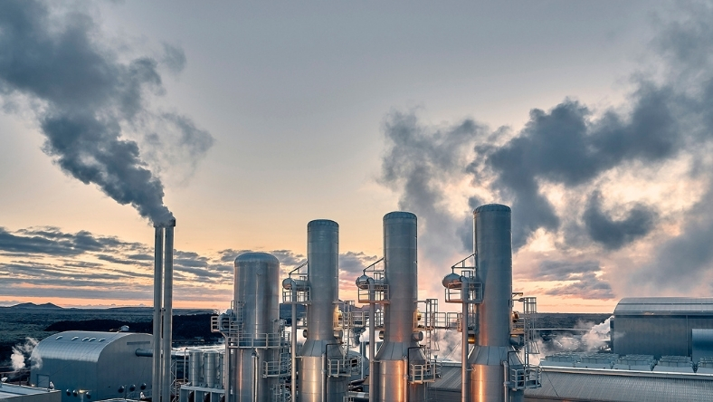 Industrial geothermal facility with steam visible from multiple vertical stacks