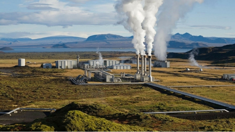 Geothermal power plant releasing steam in a remote landscape