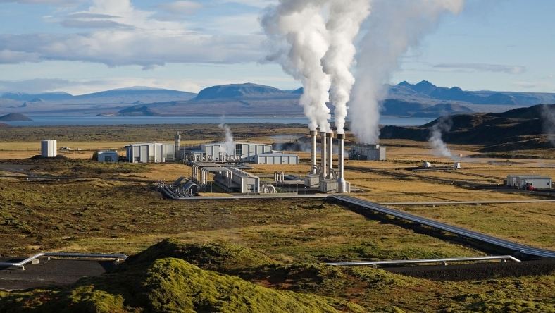 Geothermal power plant with steam rising from production wells