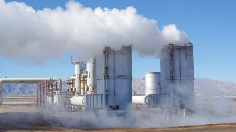 Geothermal plant with steam rising from industrial towers in arid landscape